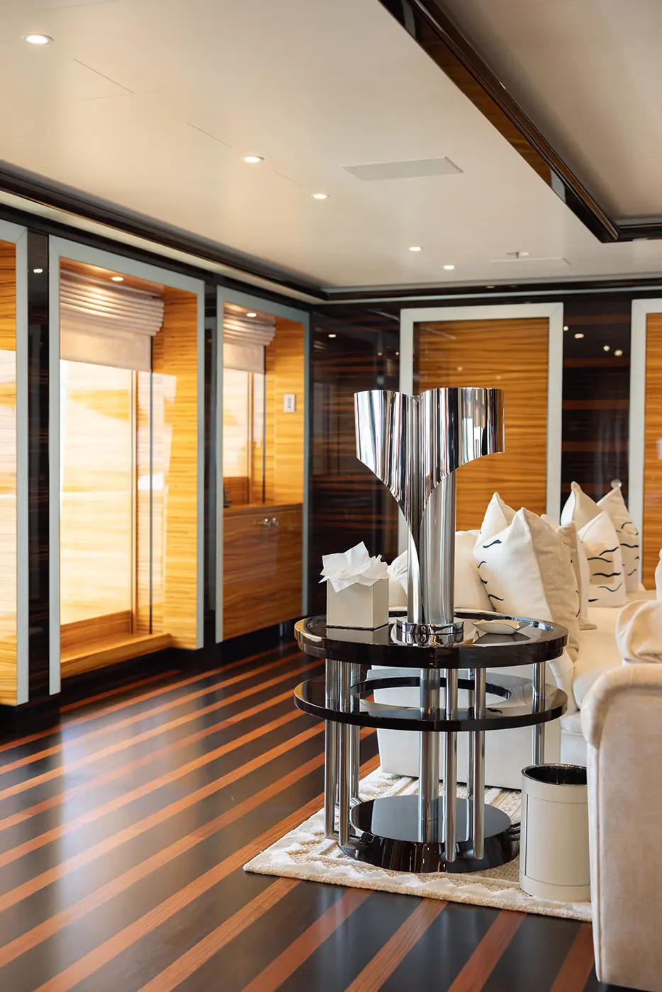 ALFA NERO sky lounge with chrome sculpture, striped floor and zebrawood walls