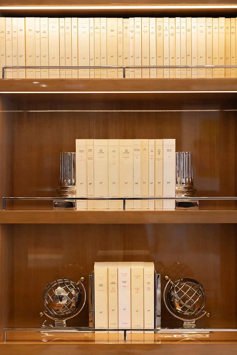 ALFA NERO library bookshelf with Gallimard cream paperbacks, crystal bookends and globe ornaments