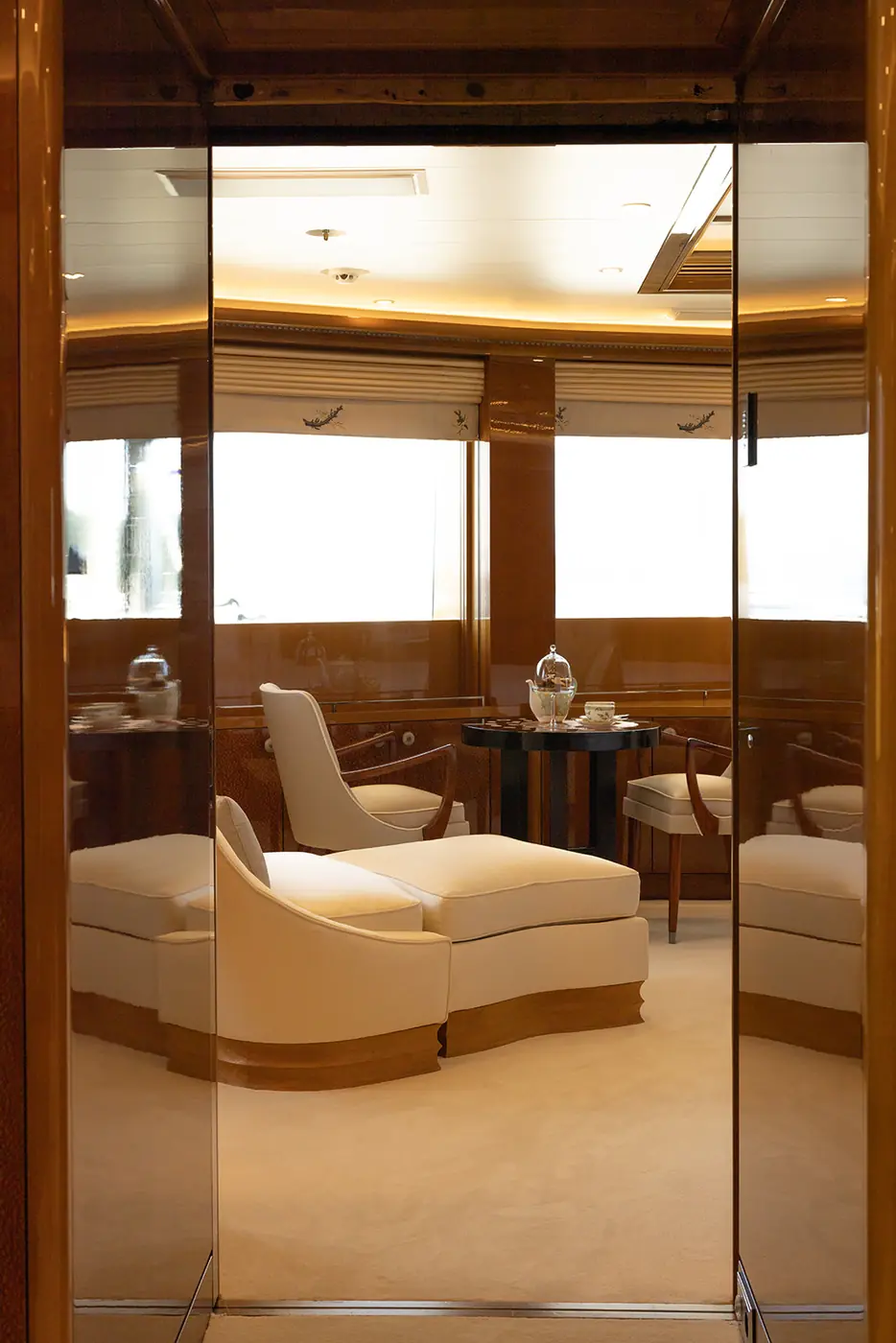 ALFA NERO master cabin private sitting area with chaise and tea set, reflected in mirrored doors